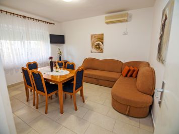 brown apartment, living room, LCD TV with satellite channels, sofa, dining room