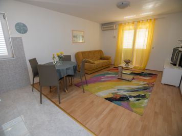 yellow apartment, living room, LCD TV with satellite channels, sofa, dining room