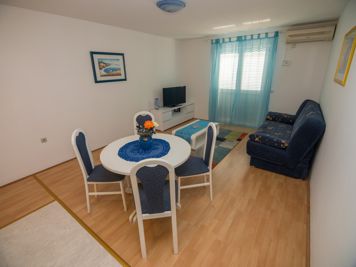 blue apartment, living room, LCD TV with satellite channels, sofa, dining room